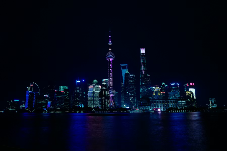 Shanghai skyline over water at night